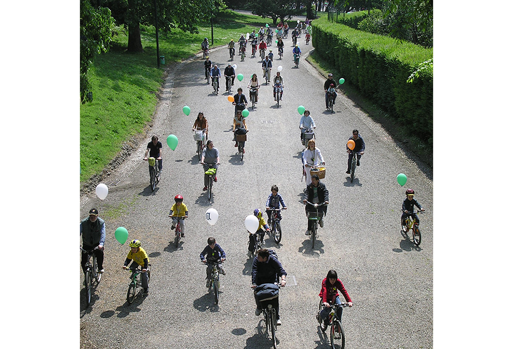 Bimbi in bici al parco con palloncini colorati